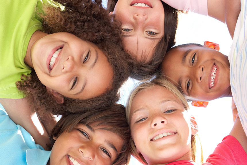 diverse circle of smiling children in a team huddle