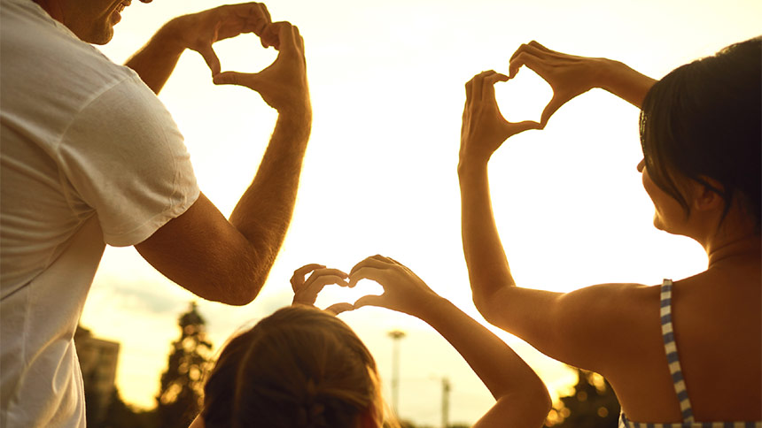 Photo of a family holding their hands in a shape of a heart