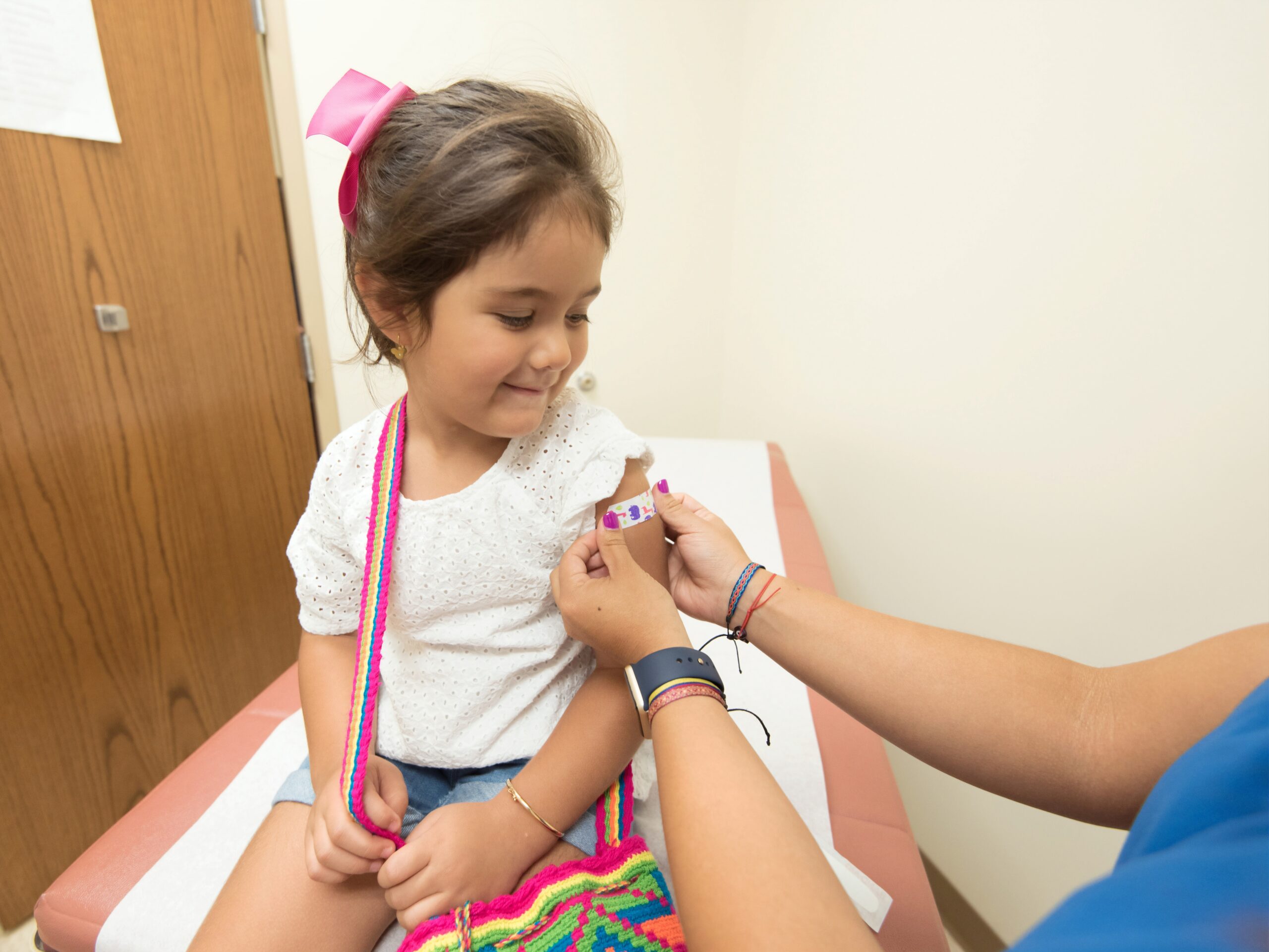 Nurse giving young girl a band aid