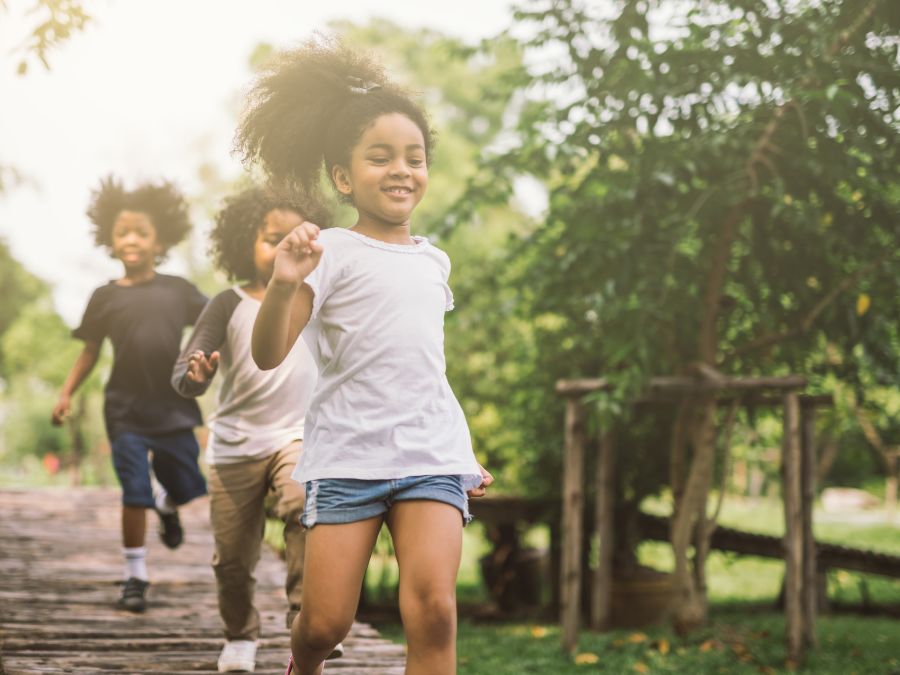 Three children running outside.