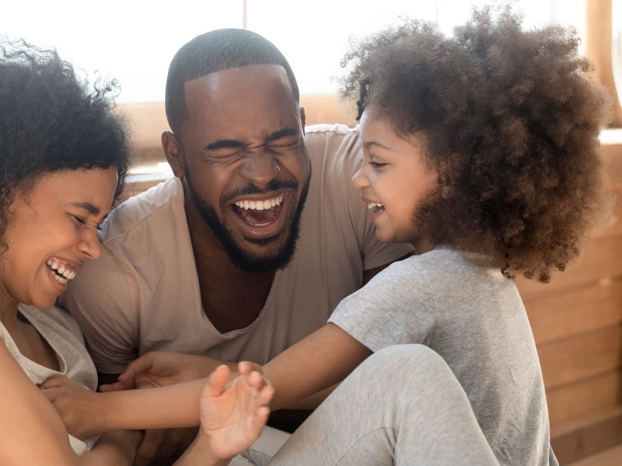 Parents and child laughing together.