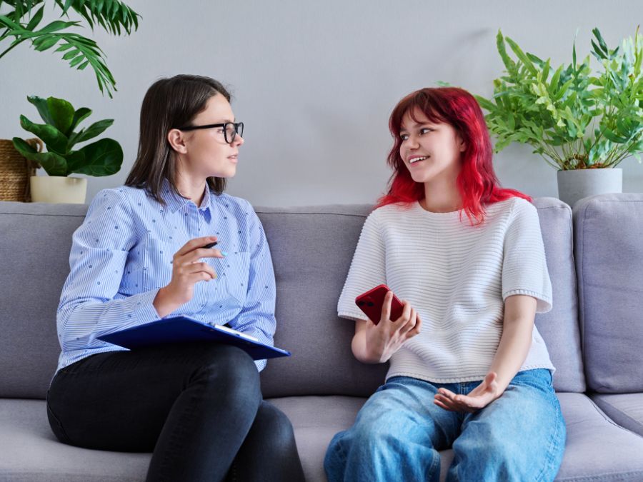 Provider and youth talking on couch.