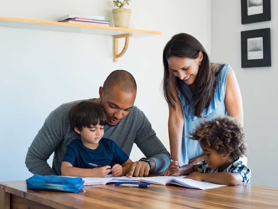 Parents helping young children with homework.